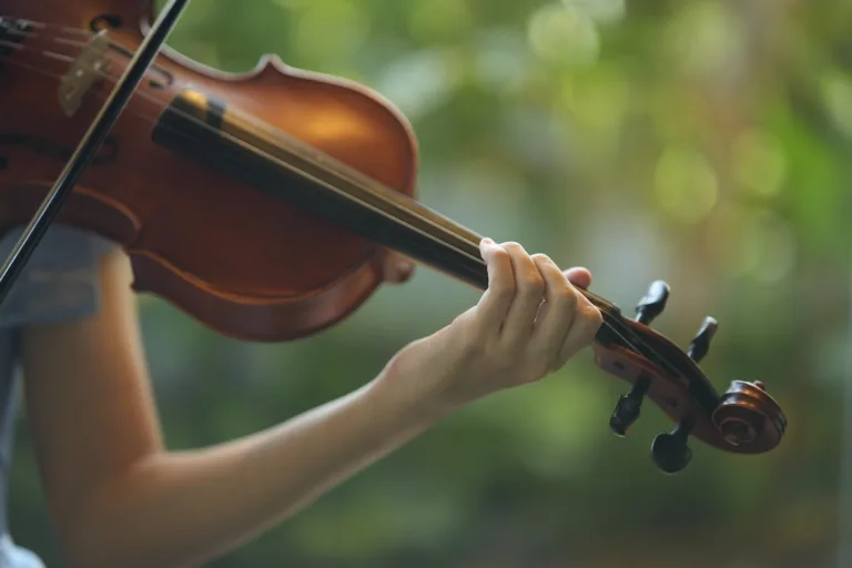 A girl playing violin with green background